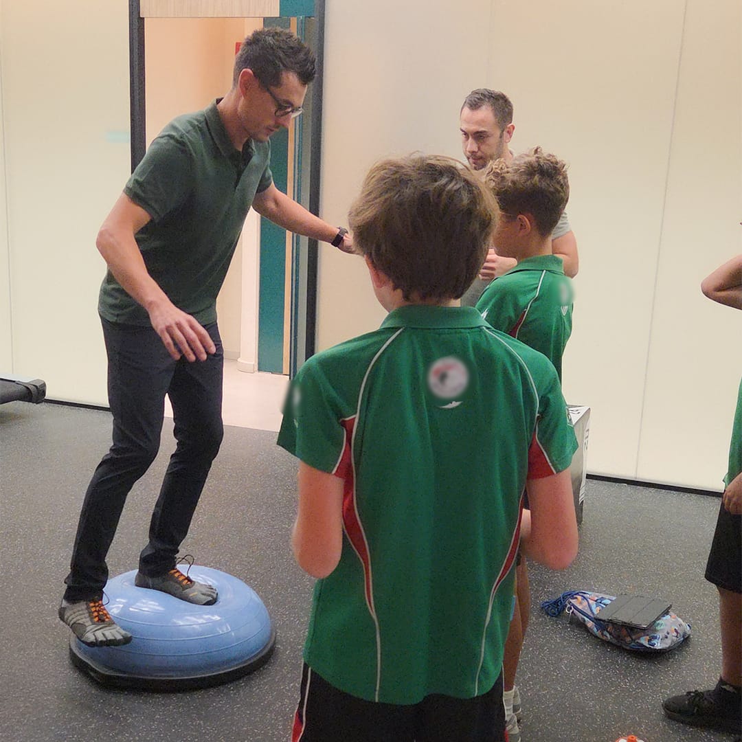 Physiotherapist leading a community exercise session at Kinesis Clinic