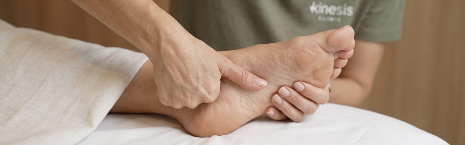 Senior physiotherapist assessing a patient's plantar fasciitis heel pain at Kinesis Clinic Dubai